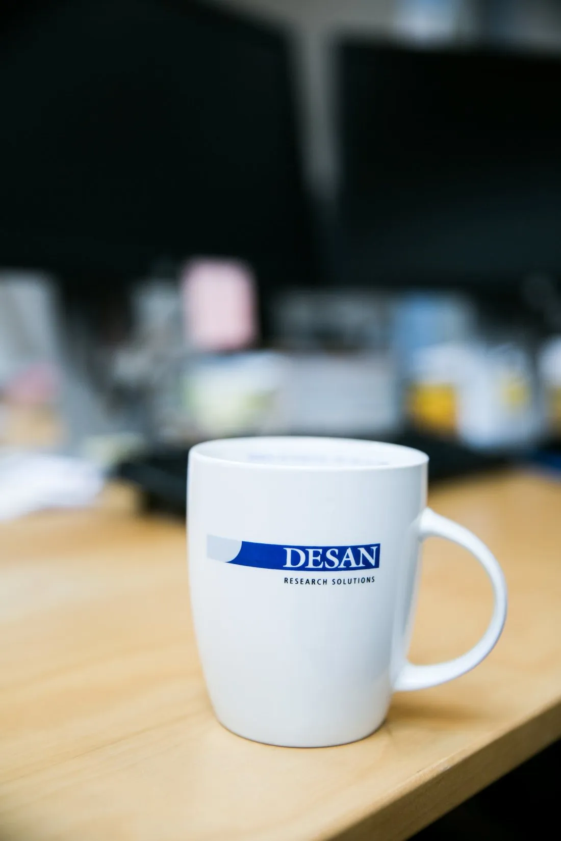 Een koffiemok met het DESAN-logo op kantoor